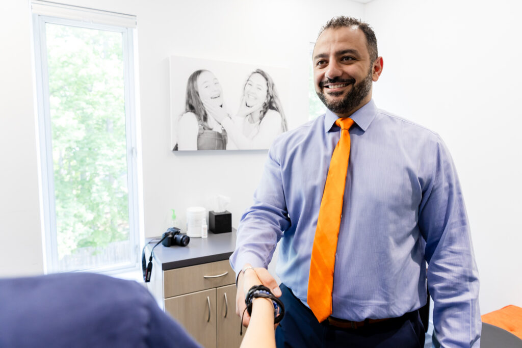 Orthodontist shaking hands with a patient after an inbrace consultation.